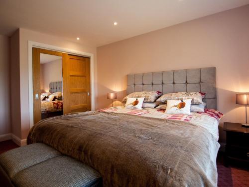 a bedroom with a large bed with two pillows at Westmains Farm in Penton