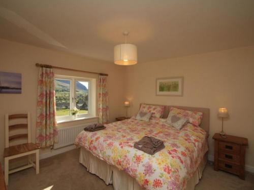 una camera da letto con un letto grande e una finestra di Eribel Cottage a Threlkeld