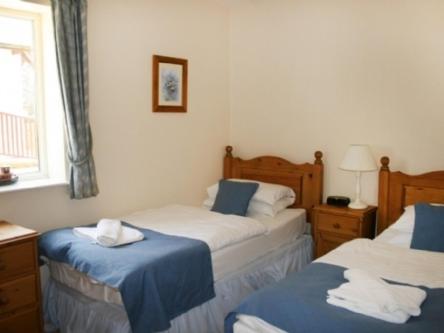 PenruddockにあるWhitbarrow Holiday Village Troutbeck 5のベッドルーム1室(青と白のシーツが備わるベッド2台付)