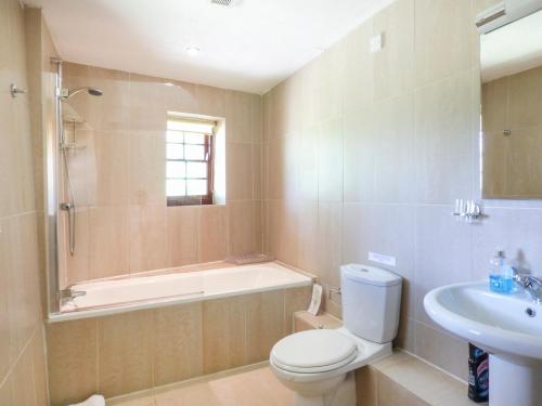 a bathroom with a tub and a toilet and a sink at Flower House in Saint Erth