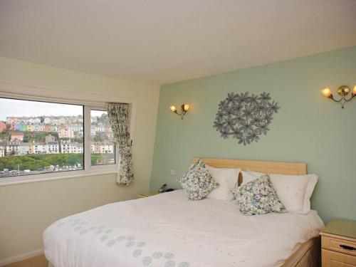 een slaapkamer met een wit bed en een raam bij Blue Horizon in Brixham
