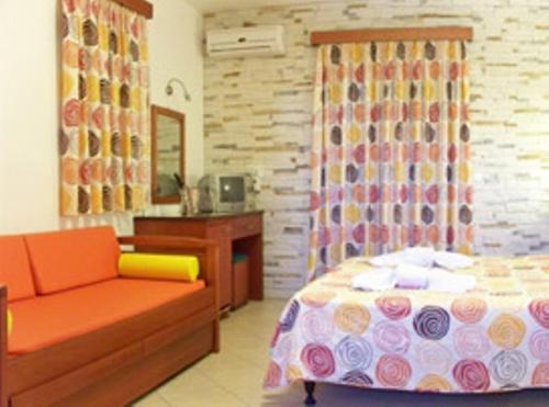 een slaapkamer met een bed, een stoel en een bureau bij Plaka Hotel II in Plaka