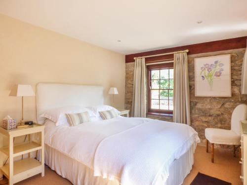 ein Schlafzimmer mit einem großen weißen Bett und einem Fenster in der Unterkunft Flower House in Saint Erth