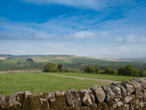 a stone wall in a field with a view at Westmains Farm in Penton