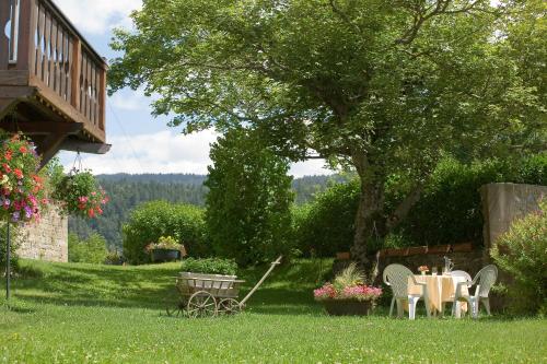 a table and chairs under a tree in a yard at La Couronne in Jougne