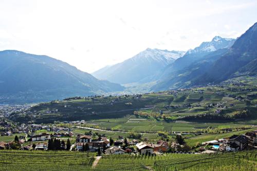 a village in a valley with mountains in the background at Schenna Garni Eden Bed & Breakfast in Schenna