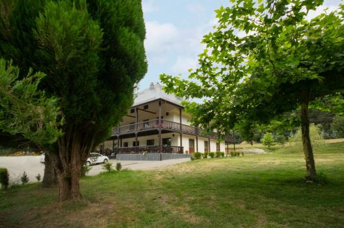 a large building with a tree in front of it at Complejo O Piñeiral A Fonsagrada in Fonsagrada