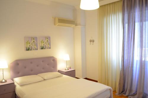 una camera con un letto, due lampade e una finestra di Pedion Areos Park 5 Center 5 ad Atene