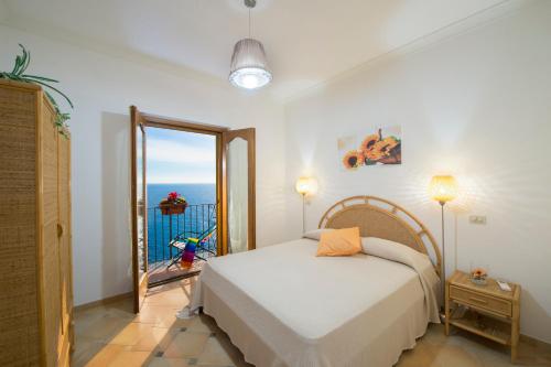 a bedroom with a bed with a view of the ocean at Casa I Girasoli in Praiano