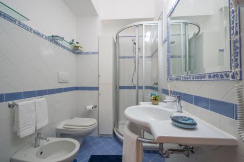 a bathroom with a sink and a toilet and a mirror at Casa I Girasoli in Praiano