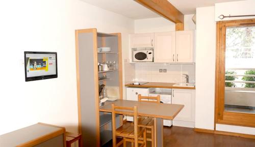 a kitchen with a table and chairs and a sink at Le Grand Chalet - Le Studio in Brides-les-Bains