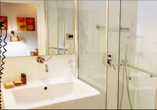 a white bathroom with a sink and a shower at Hotel Il Guercino in Bologna