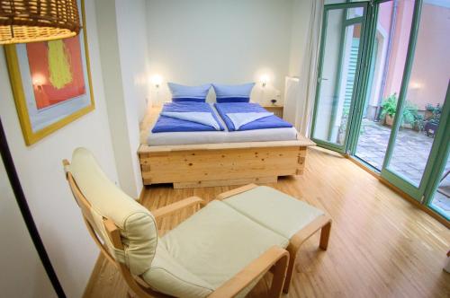 a small bedroom with a bed and a chair at Fewo CANALETTO im Stadtzentrum in Dresden