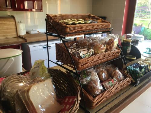 a counter with baskets of bread and other food at Glan Llyn Farm House in Mold
