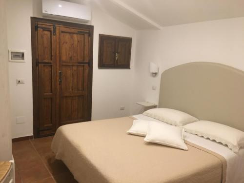 a bedroom with a bed and a wooden door at B&B La Quiete in Massa Lubrense