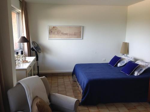 サントロペにあるSaint-Tropez - Studio 40 m2のベッドルーム(青いベッド1台、椅子付)