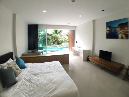 Mida de Sea Residence Hua Hin في تشا أم: غرفة نوم فيها سرير وتلفزيون