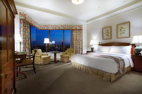 a hotel room with a bed and a desk and a window at Hotel Chinzanso Tokyo in Tokyo