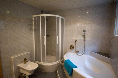 a bathroom with a shower and a tub and a toilet at Ferienlandhaus Höfer in Fulpmes