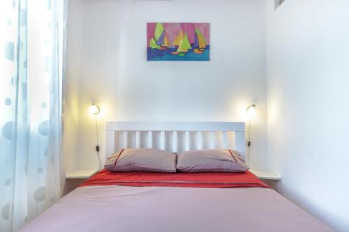 a bed with two pillows and a painting on the wall at Charming City Center in Podgorica