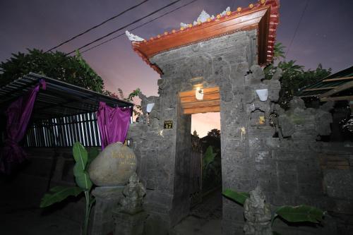 a stone building with a doorway with a roof at Teba Jati Guest House in Ubud
