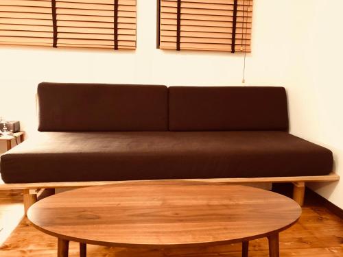 a couch sitting in a room with a coffee table at Pension Razteca in Hakuba
