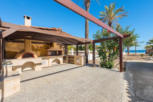 an outdoor patio with a pizza oven in front of the beach at Villa Maria Beachfront Residence in Kiotari