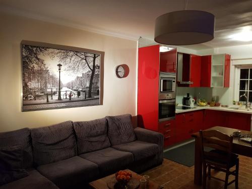 a living room with a couch and a kitchen with red cabinets at Villa - zeezicht, zwembad in Nerja