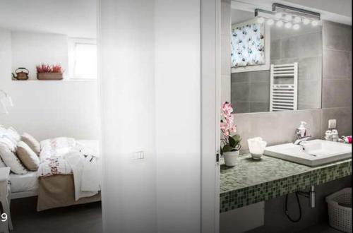 a bathroom with a sink and a bed and a mirror at Casa Vacanze con Sauna in Castronno