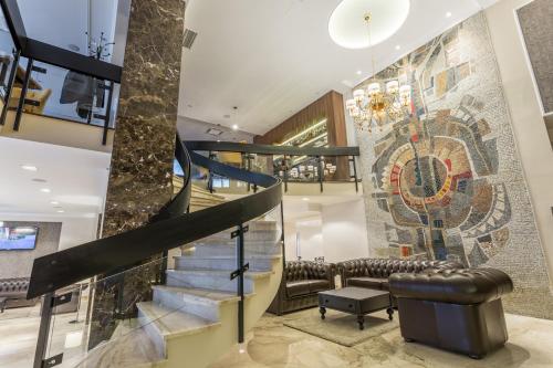 a lobby with a staircase and a mosaic wall at Hotel Royal Inn in Belgrade