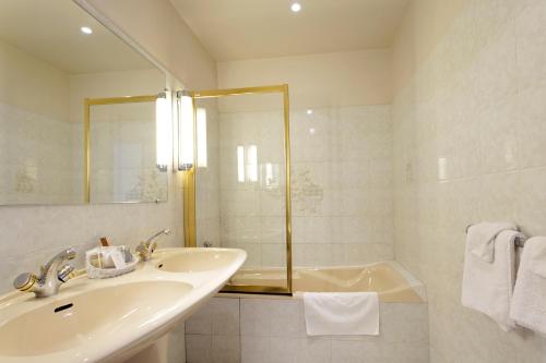 a white bathroom with a sink and a tub at Château Des Bondons EI in La Ferté-sous-Jouarre