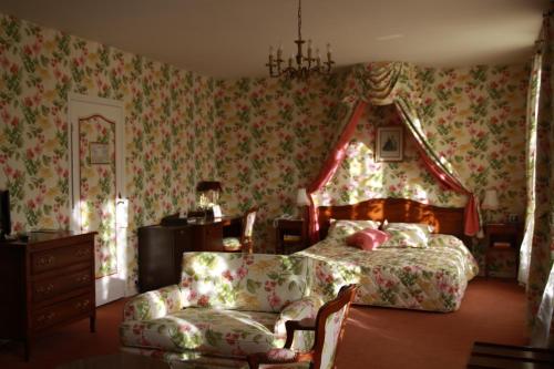 a bedroom with a bed and a chair and a couch at Château Des Bondons EI in La Ferté-sous-Jouarre