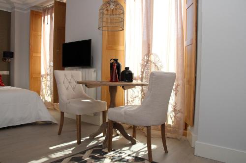 a living room with a table and two chairs at Principia Suites in León