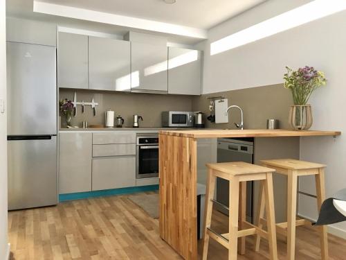 a kitchen with stainless steel appliances and wooden stools at Apartment Santa Teresa in Altea