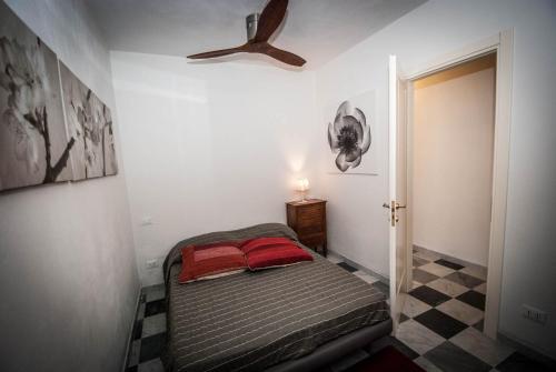 a small bedroom with a bed and a ceiling fan at Luxury Seaview Apartments Manarola by Arbaspàa in Manarola