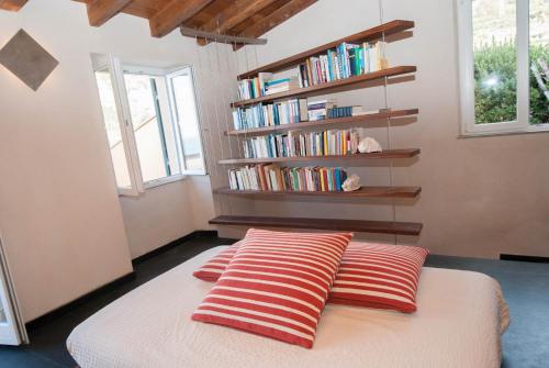 a bedroom with two pillows and a book shelf at Luxury Seaview Apartments Manarola by Arbaspàa in Manarola