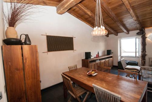 a dining room with a wooden table and chairs at Luxury Seaview Apartments Manarola by Arbaspàa in Manarola