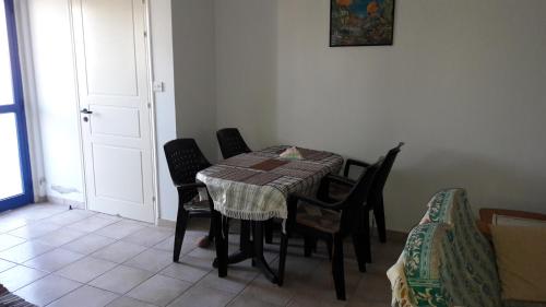 a dining room with a table and chairs and a door at Rita SeaView Apartment in Pervolia