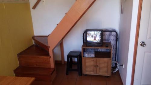 a staircase with a tv sitting on a stand in a room at Cabaña 1 Neuling-Reñaca in Viña del Mar