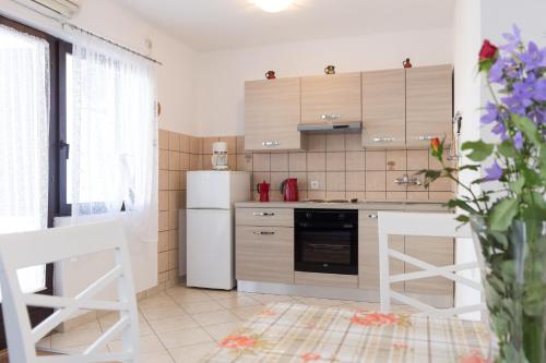 kuchnia z białymi urządzeniami i białą lodówką w obiekcie Apartments Karen w Krku