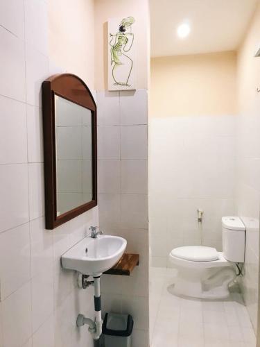 a bathroom with a sink and a toilet and a mirror at El Homestay Bali in Nusa Dua