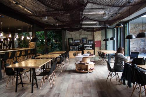 a woman sitting at a table in a restaurant at 7 Gaia Roaster Apartments in Vila Nova de Gaia