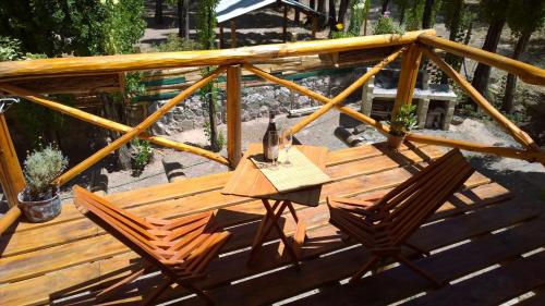 a wooden deck with two chairs and a table at Balcon de Antares in Uspallata