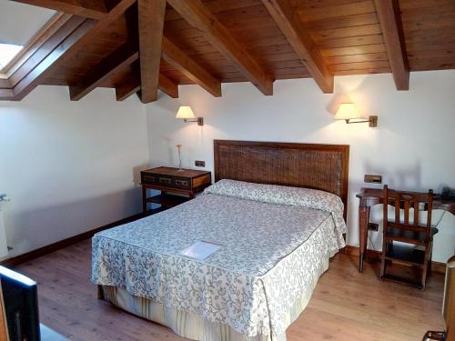 a bedroom with a bed and a table and a chair at Hotel Aldama Golf in Quintana de Llanes
