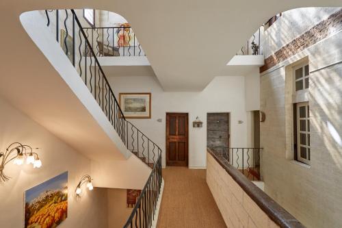 a winding staircase in a home with white walls and wooden ceilings at Hotel De L'Atelier in Villeneuve-lès-Avignon