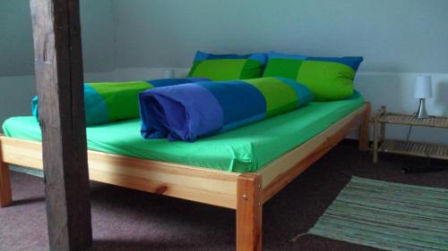 a bed with green and blue pillows on it at Apartment unterm Dach in Wismar