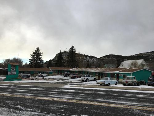 a parking lot with cars parked in front of a building at Raton Pass Motor Inn in Raton
