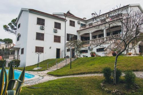a large white building with a pool in front of it at Jantesta Guest House in Coimbra