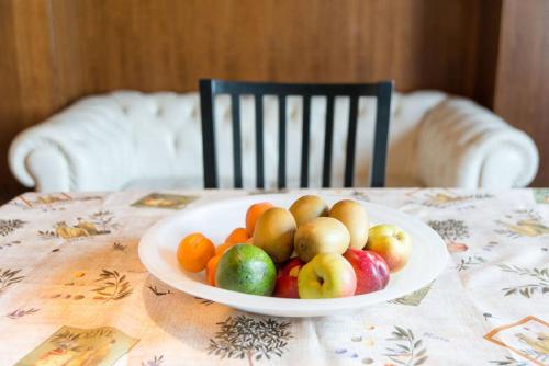 a bowl of fruit on a table with a chair at Il Molino Apartment in Venice