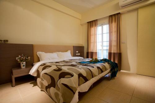 1 dormitorio con 1 cama grande y ventana grande en Richie Homestay, en Hualien City